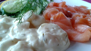 Gravlask med dillpoteter og agurk på tallerken.